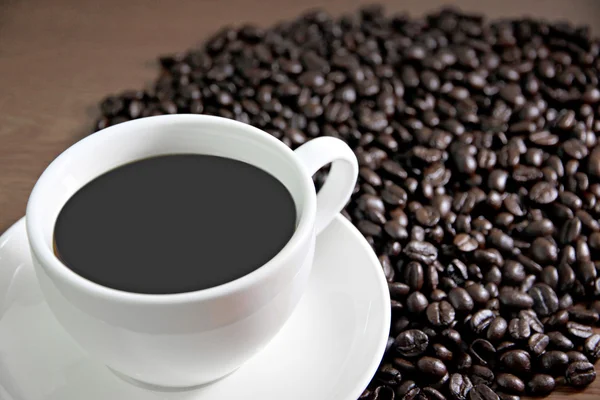 Kaffeetasse und Kaffeebohnen auf dem Tisch altes Holz. — Stockfoto