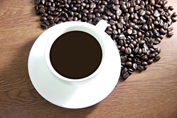 Coffee cup and coffee beans on the table old wood. — Stock Photo, Image