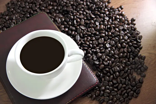 Tasse à café blanche et livre sur la table vieux bois Près du café — Photo