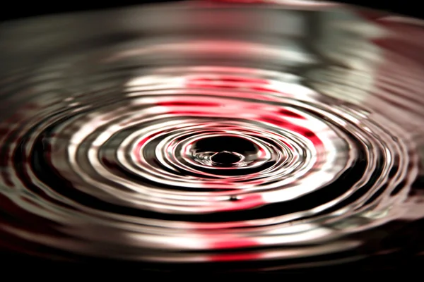 Fundo vermelho de gotas de água uma forma bonita na bacia . — Fotografia de Stock
