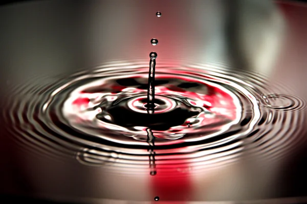 Красный фон воды роняет красивую форму в бассейне . — стоковое фото