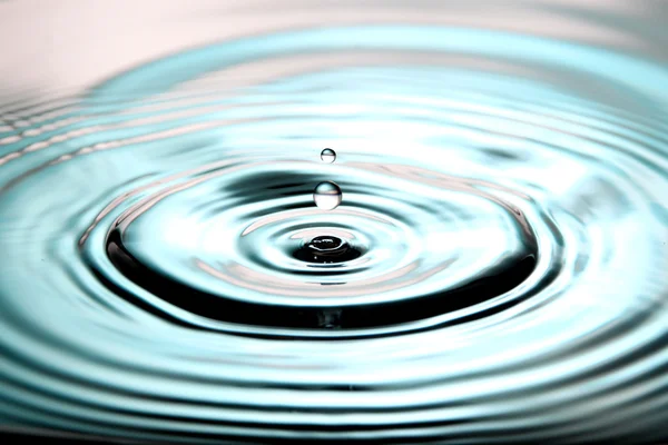 Blauer Hintergrund des Wassers fällt eine schöne Form in Becken. — Stockfoto