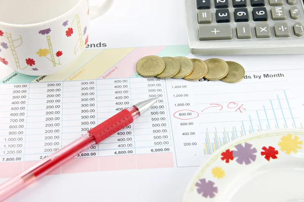 ビジネス グラフに赤ペン、カップ、電卓、お金のコイン. — ストック写真