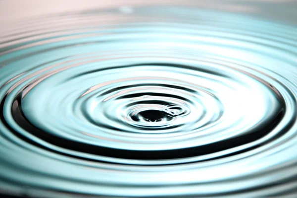 Fondo azul de gotas de agua de la ondulación en la cuenca . — Foto de Stock