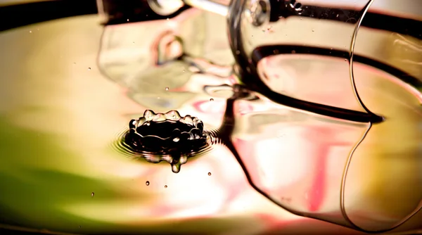 Água cai uma bela forma e bebida de vidro na bacia . — Fotografia de Stock