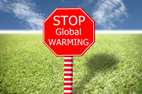 Röda etiketter med texten global uppvärmning på gräs och blå himmel. — Stockfoto