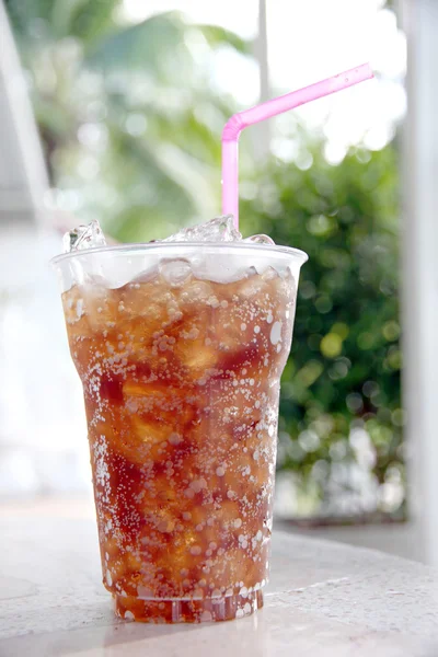 Cola-Getränke im Plastikbecher auf dem Tisch. — Stockfoto