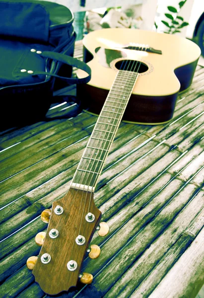 Kytara na bambusový stůl. — Stock fotografie