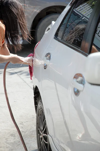 Witte auto wassen met waterslang in huis. — Stockfoto