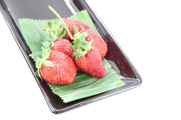 Four Strawberry in black dish.