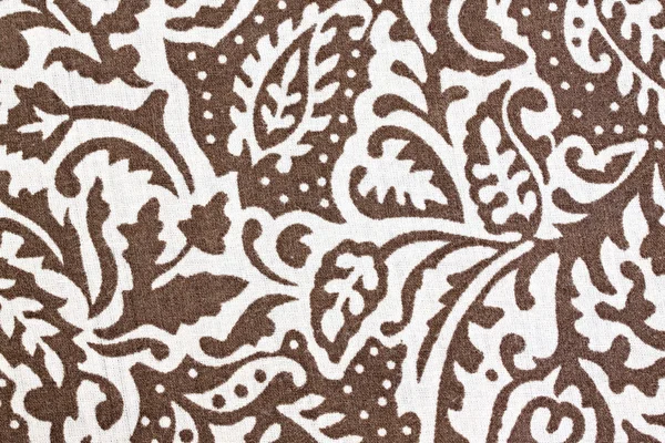 White patterned leaves on brown fabric. — Stock Photo, Image