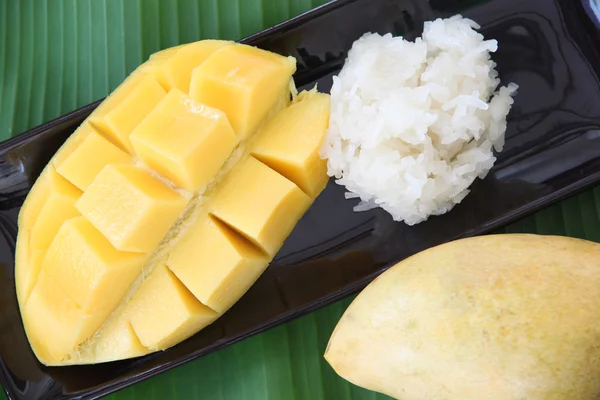 Mangue mûre et riz collant dans un plat sur des feuilles de banane . — Photo