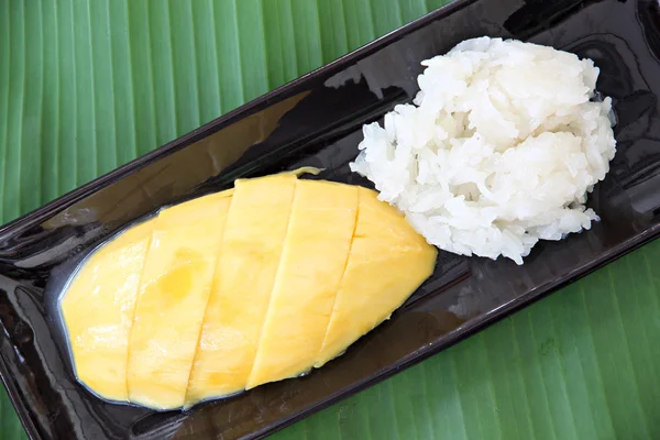 Mango maduro y arroz pegajoso en plato sobre hojas de plátano . —  Fotos de Stock
