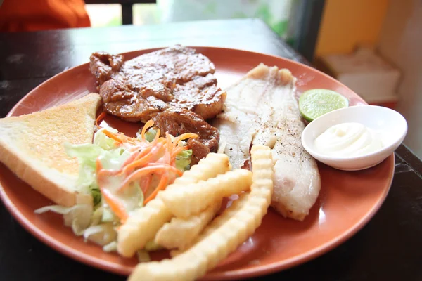 Steak de porc grillé avec frites et pain grillé . — Photo