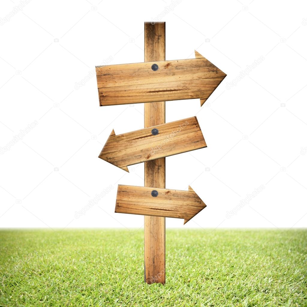Wooden signpost of dark planks on lawn.