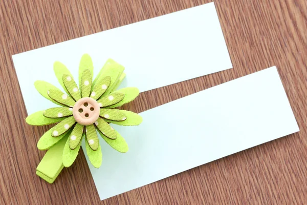 Flores artificiales verdes y papel de nota pegado en madera oscura . —  Fotos de Stock