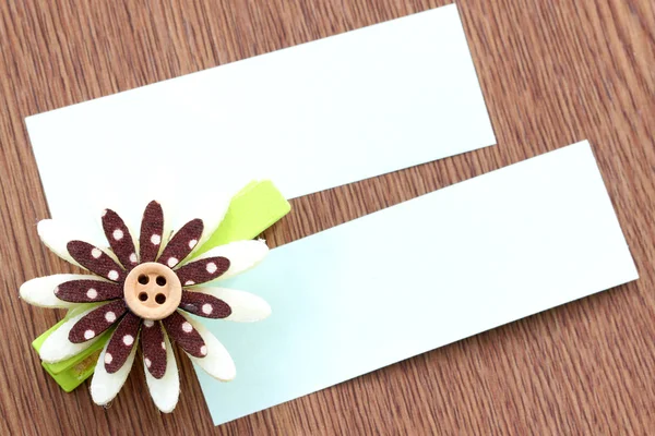 Brown artificial flowers and note paper stuck on dark wood. — Stock Photo, Image