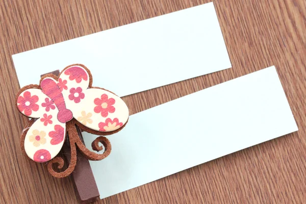 Brown artificial butterfly and note paper stuck on dark wood. — Stock Photo, Image