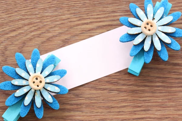 Fiori artificiali blu e carta da lettere incollati su legno scuro . — Foto Stock