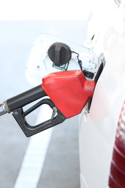 Red fuel nozzle in pouring to car. — Stock Photo, Image