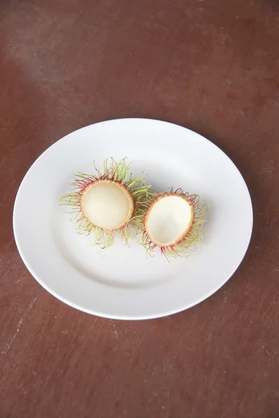 Frutta fresca di rambutan di peeling in piatto . — Foto Stock