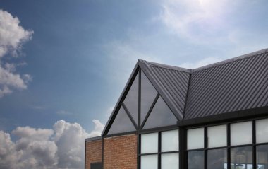 Çalışmalarınızda tasarım için mavi gökyüzü arka planındaki modern ev çatısı.