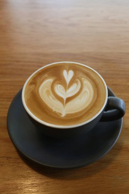 Kahve fincanları bir kahve dükkanında bir masaya yerleştirilmiş, beyaz bardakta Latte sanat eserleri iş konseptinizde tasarım için bir kafede..