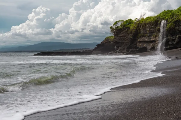 Wild beach with black sand and waterfall — Stock Photo, Image