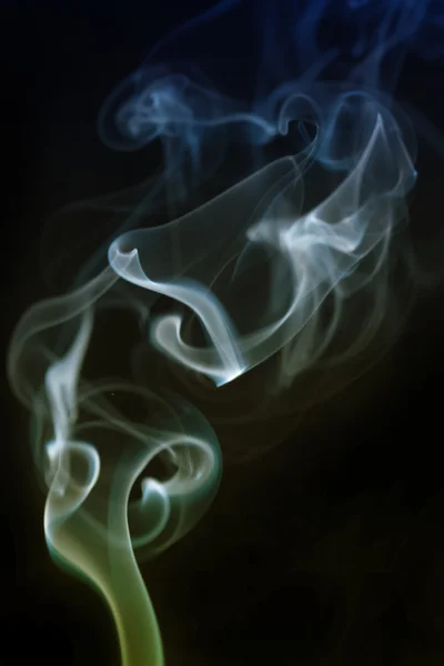 Swirling smoke from the incense on a homogeneous background — Stock Photo, Image