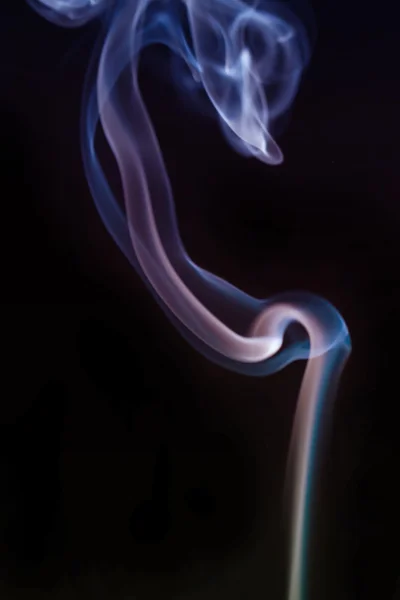Wervelende rook uit de wierook op een homogene achtergrond — Stockfoto