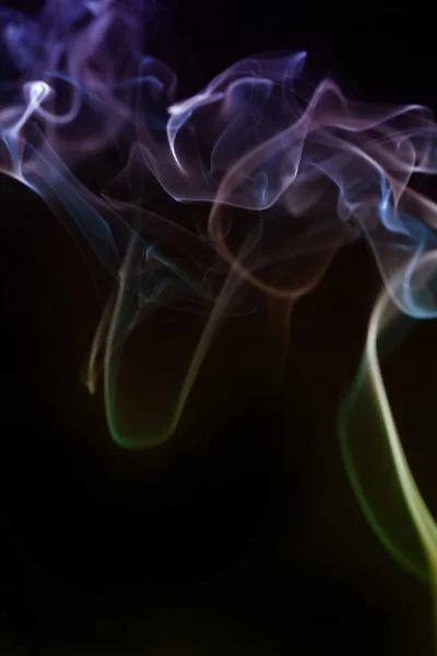 Wervelende rook uit de wierook op een homogene achtergrond — Stockfoto