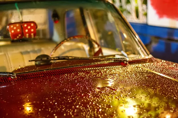 Rotes Retro-Auto, das im Regen auf einer Straße steht — Stockfoto