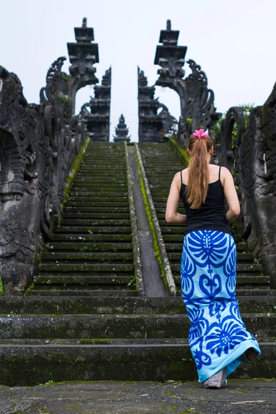 Girl climbing the stairs to the temple — Stock Photo, Image