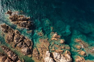 Taş kıyı şeridi ve turkuaz deniz suyu