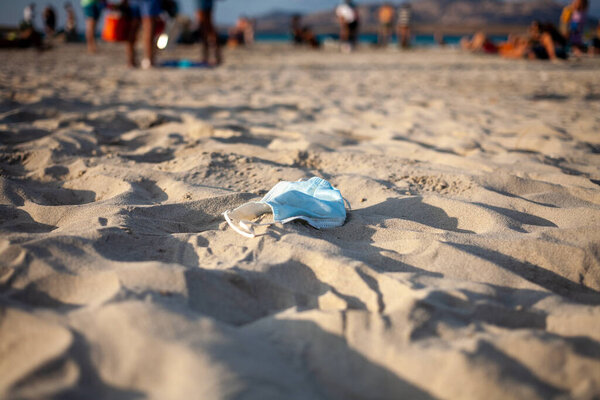 Одноразовая медицинская маска на берегу моря