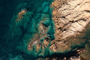 Taş kıyı şeridi ve turkuaz deniz suyu