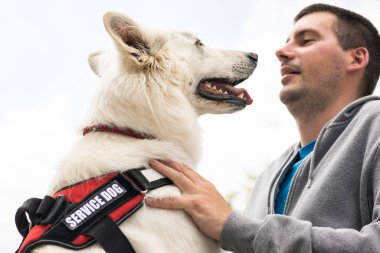 Özürlü ve hizmet köpeği olan bir adam.