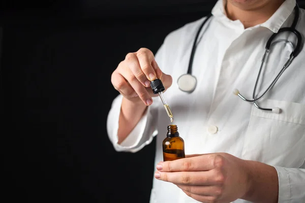 Doctor hands opening a glass pipette CBD oil bottle — Φωτογραφία Αρχείου