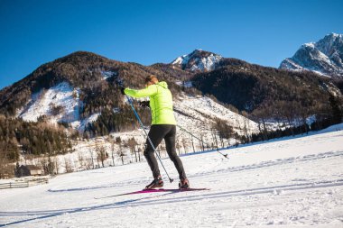 Bir erkek kayakçı eğlence amaçlı olarak kros kayağı yapıyor.