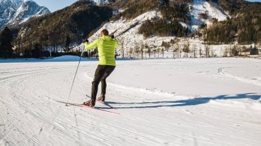Bir erkek kayakçı eğlence amaçlı olarak kros kayağı yapıyor.