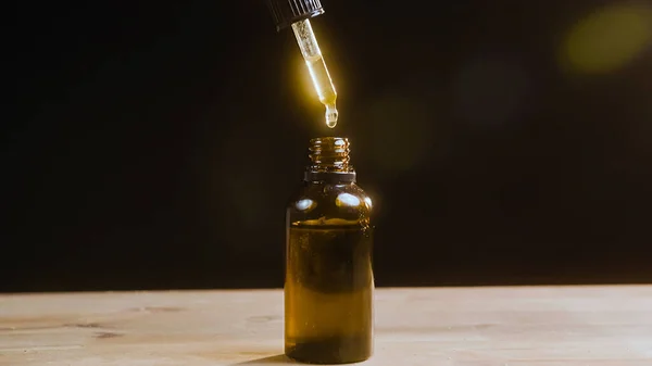 Filling a glass dropper bottle with CBD hemp oil — Stock Photo, Image