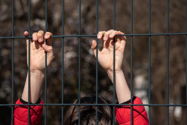 Дитячий біженець за металевим парканом — стокове фото