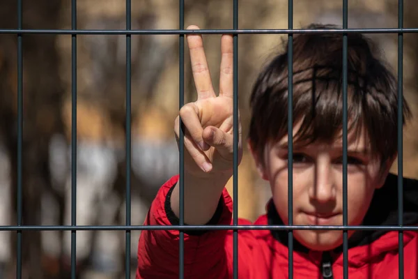 Metal bir çitin arkasında çocuk mülteci var — Stok fotoğraf