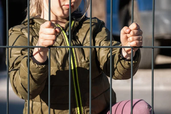 Fémkerítést tartó gyermek menekült kéz — Stock Fotó