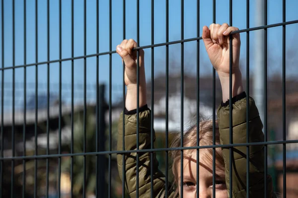 Metal bir çitin arkasında çocuk mülteci var — Stok fotoğraf