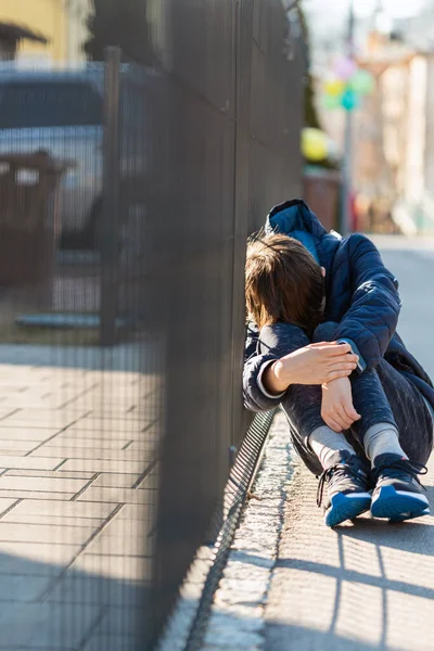 Üzgün çocuk sokakta oturup ağlıyor. — Stok fotoğraf