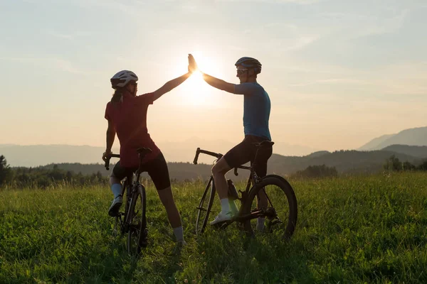 Ciclista casal dando um alto cinco para o outro — Fotografia de Stock