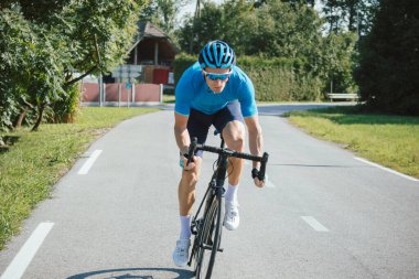 Bisikletli bir adam yarış pisti pozisyonunda.