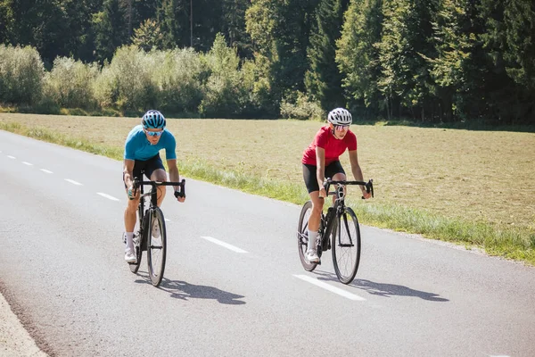 İki profesyonel bisikletçi, erkek ve kadın.