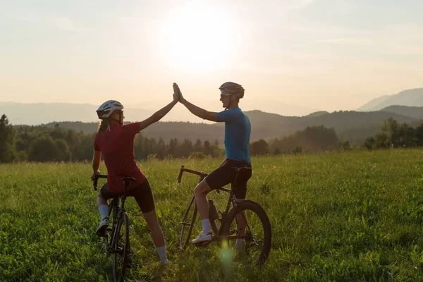 Dois ciclistas celebram uma conquista de corrida com um gesto alto de cinco — Fotografia de Stock